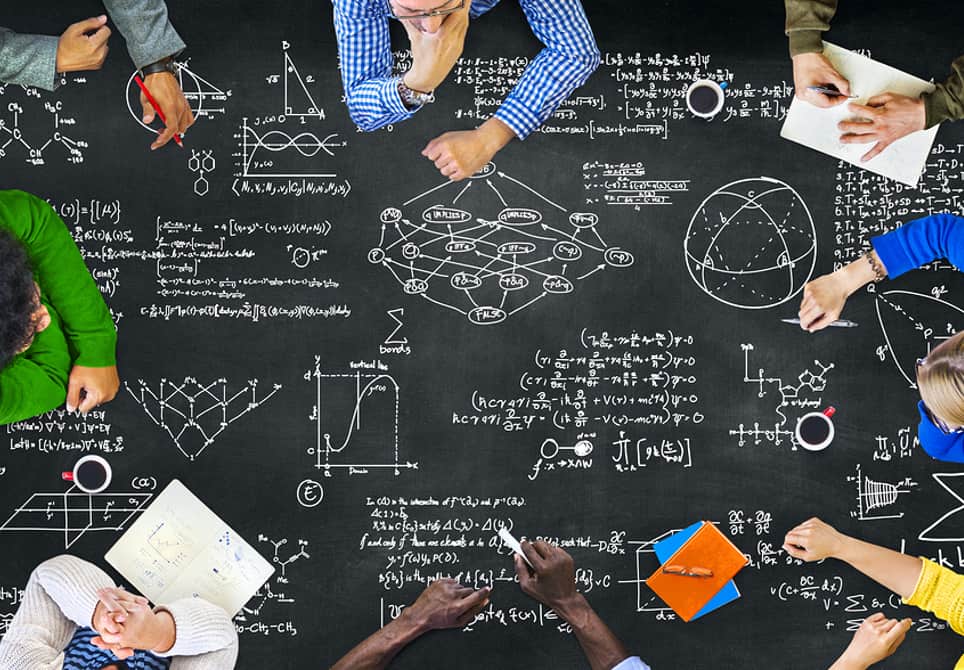 a group of students sitting around a table studying math