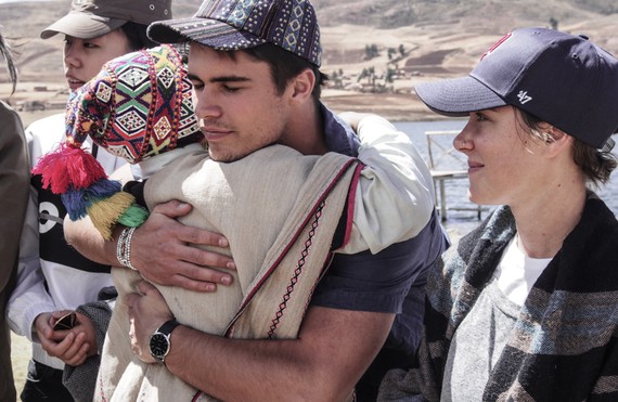 TGS student being hugged by man in white robe and brightly colored alpaca hat