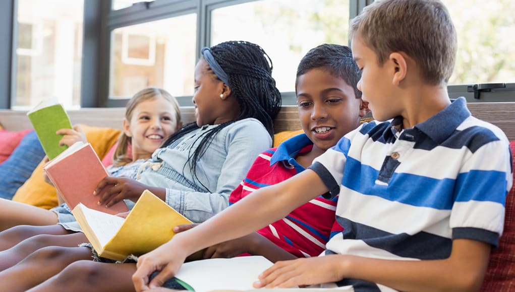 students reading on a couch and closing the achievement gap between themselves and other students