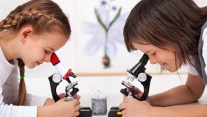 Two girls using microscopes, a fun way to get more girls involved in STEM