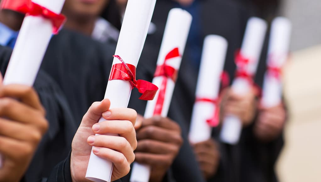 students holding diplomas at graduation, thanks to proficiency-based education