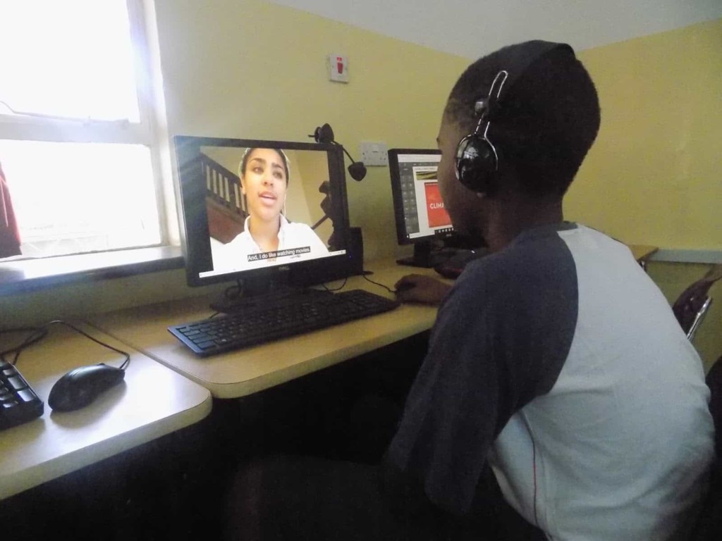 african student using computer to chat with american girl and take part in global collaboration for a computer science program