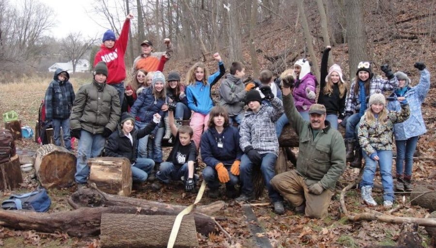 Groupd of student standing outdoors in a forest, engaging in place-based education