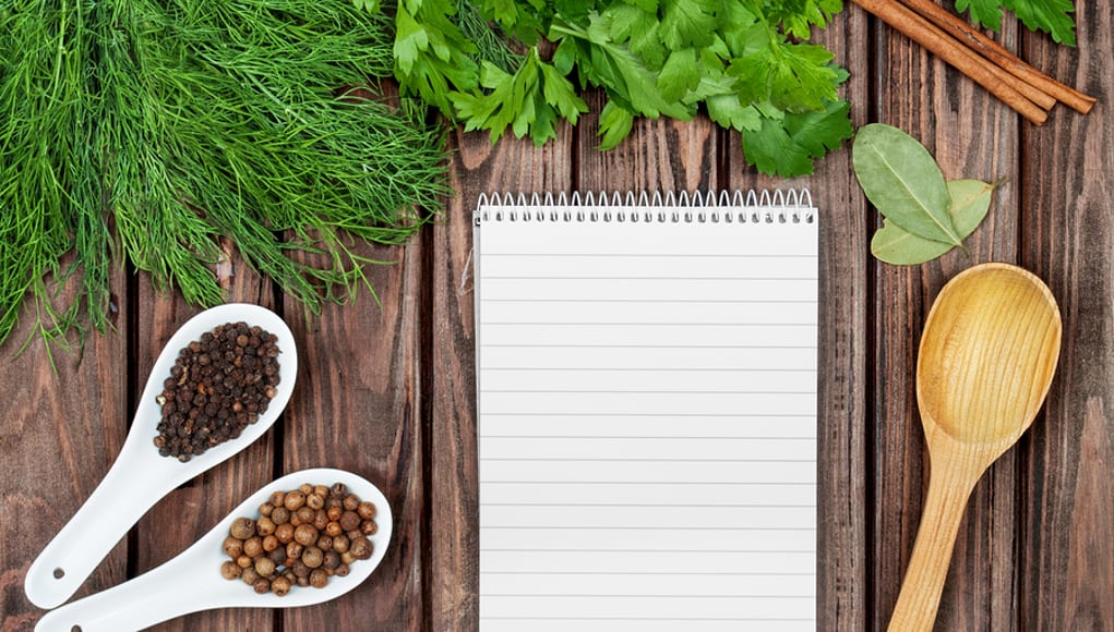 A collection of fresh herbs and spices with a wooden spoon and notepad, meant to symbolize the ingredients for a teacher pd revolution