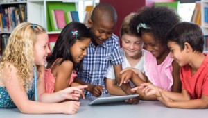 Yound students using a tablet as part of their early education and learning
