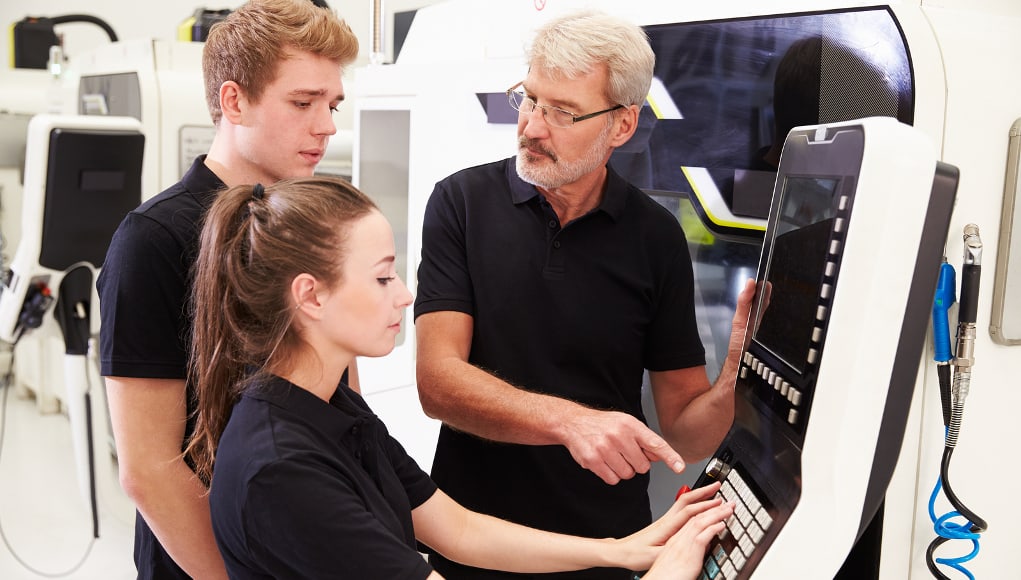 two students using medical machine as part of a high school internship