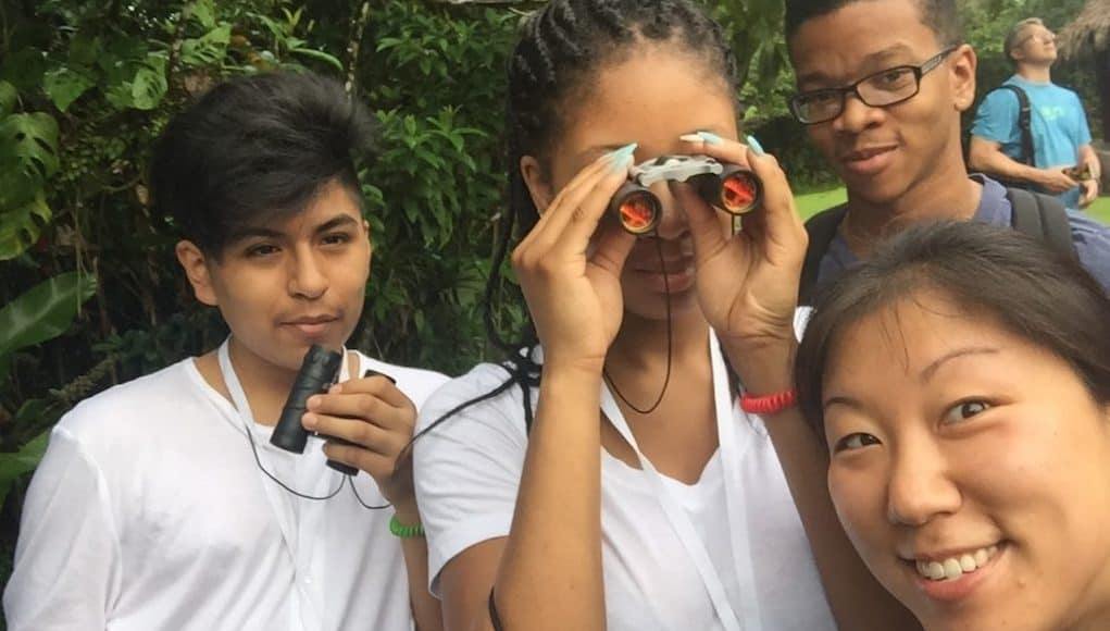 4 young students in a jungle engaging in place-based ed