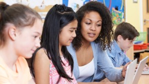 teacher helping student on computer in a personalized program for learning