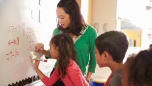 teacher writing on whiteboard with student in personalized learning lesson