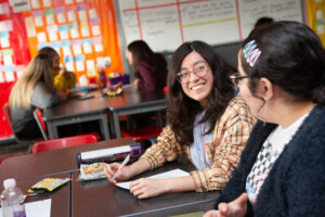 Two high school girls discuss their research topics during an AP research class.