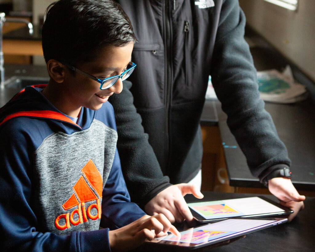 Two middle school boys work together on a coding project.