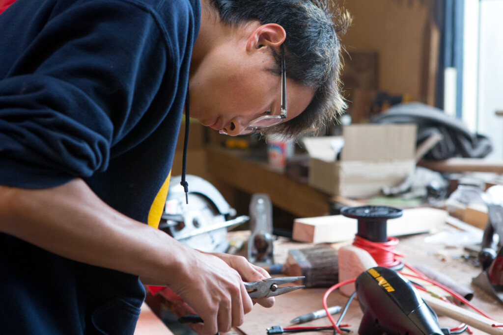 A student snips wires for a boat-building project.