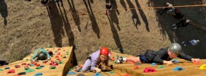 Student climb the rock wall at the adventure park.